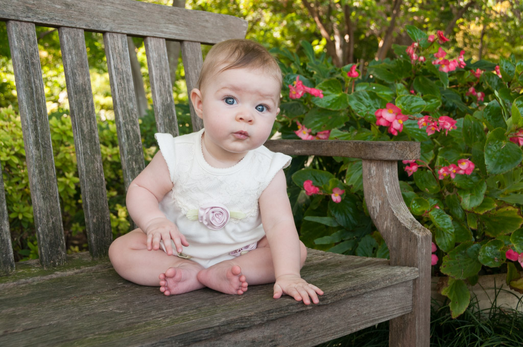 Bridget seated on a bench at the Dallas Arboretum